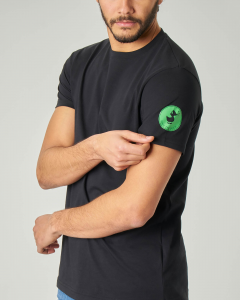 T-shirt nera con logo bollo verde sulla manica