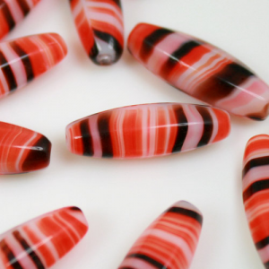 Elongated pearl in orange, white and black striped glass paste, 23 mm