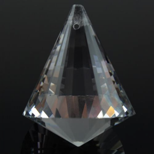 Prisma sfaccettato in vetro molato color cristallo, altezza 40 mm. Foro passante in cima.