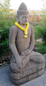 Statua Buddha seduto in pietra balinese con tunica ricamata